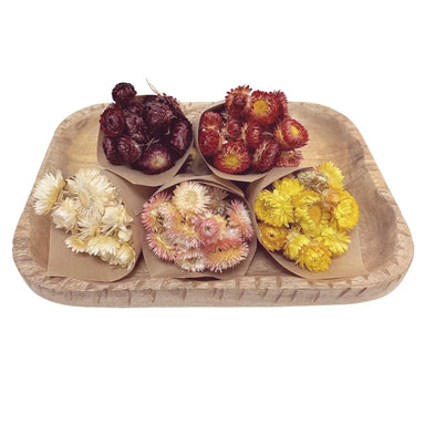 Wooden tray with dried flowers and fruits on a white background