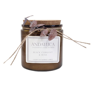 Brown glass candle cup with cork lid and eucalyptus tied to glass.