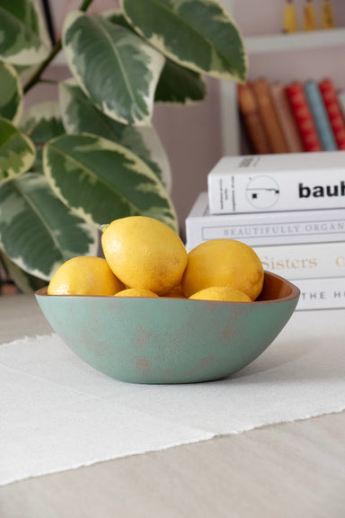 Small bowl of the Set of 3 Turquoise Copper Cast Metal Decorative Bowls, empty bowls in room setting, filled with lemons.