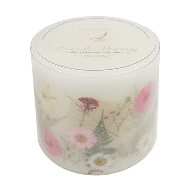 Ivory pillar candle with delicate pink and ivory pressed flowers and green leaves decorating the outside of the candle.