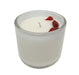 White candle cup with red stones in wax.