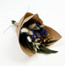 Mini bouquet with purple larkspur, willow eucalyptus, bunny tails, flax, and aveena in kraft paper wrap with jute tie.