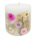 Ivory pillar candle with delicate pink and ivory pressed flowers and green leaves decorating the outside of the candle.