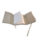 Beige suede journal with white pages.