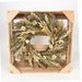 A dried flower wreath made of natural beige, brown, and green botanicals, displayed inside a square light wood crate on a white background.