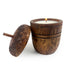 Acorn Wood Candle lit on a white background.