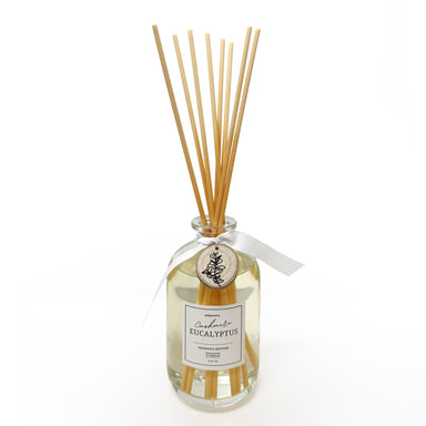 Reed diffuser with wooden sticks and a label on a white background