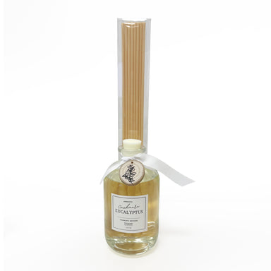 Bottle of eucalyptus essential oil with a label and a small container of eucalyptus leaves on a white background