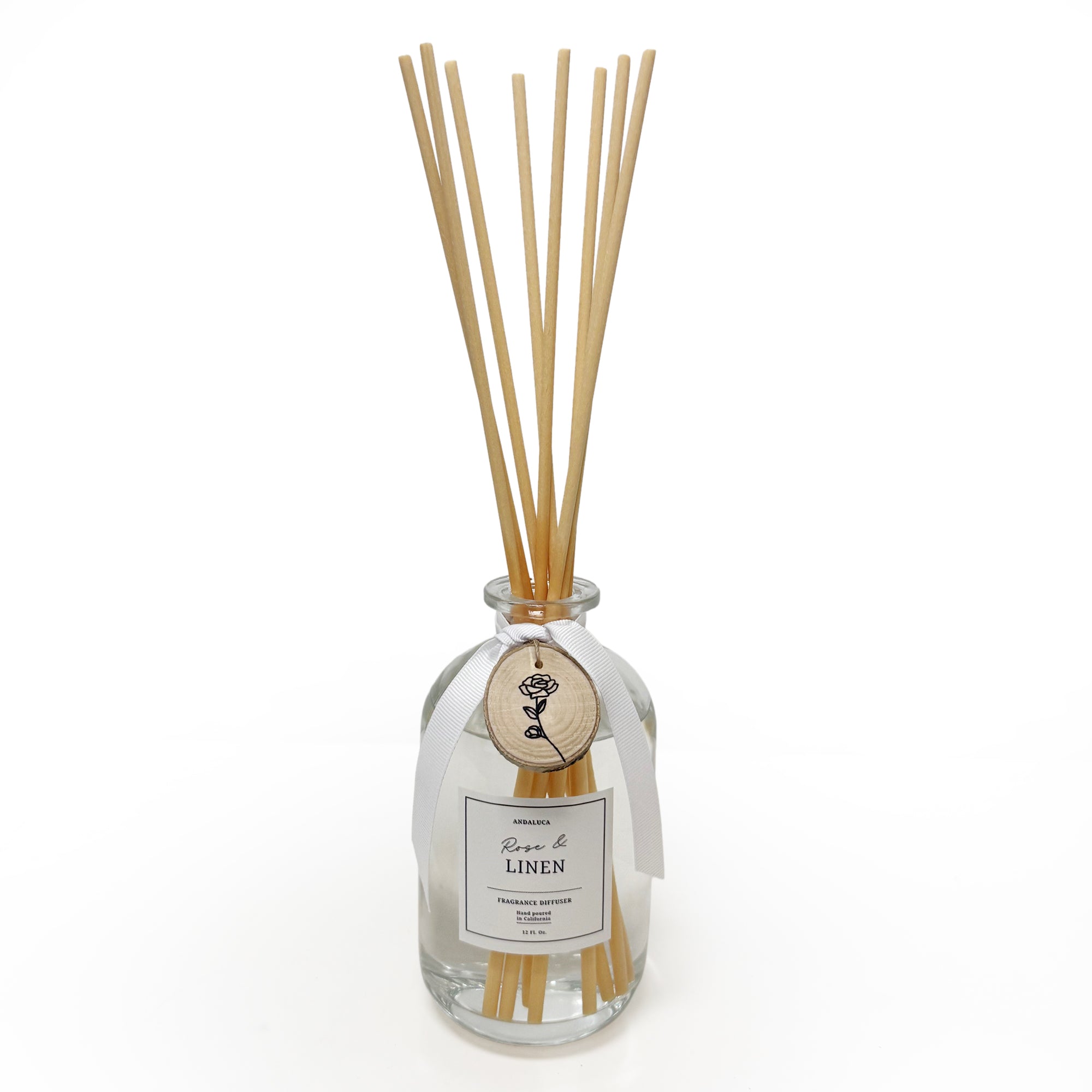 Reed diffuser with wooden sticks in a clear bottle on a white background