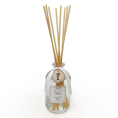 Reed diffuser with wooden sticks in a clear bottle on a white background