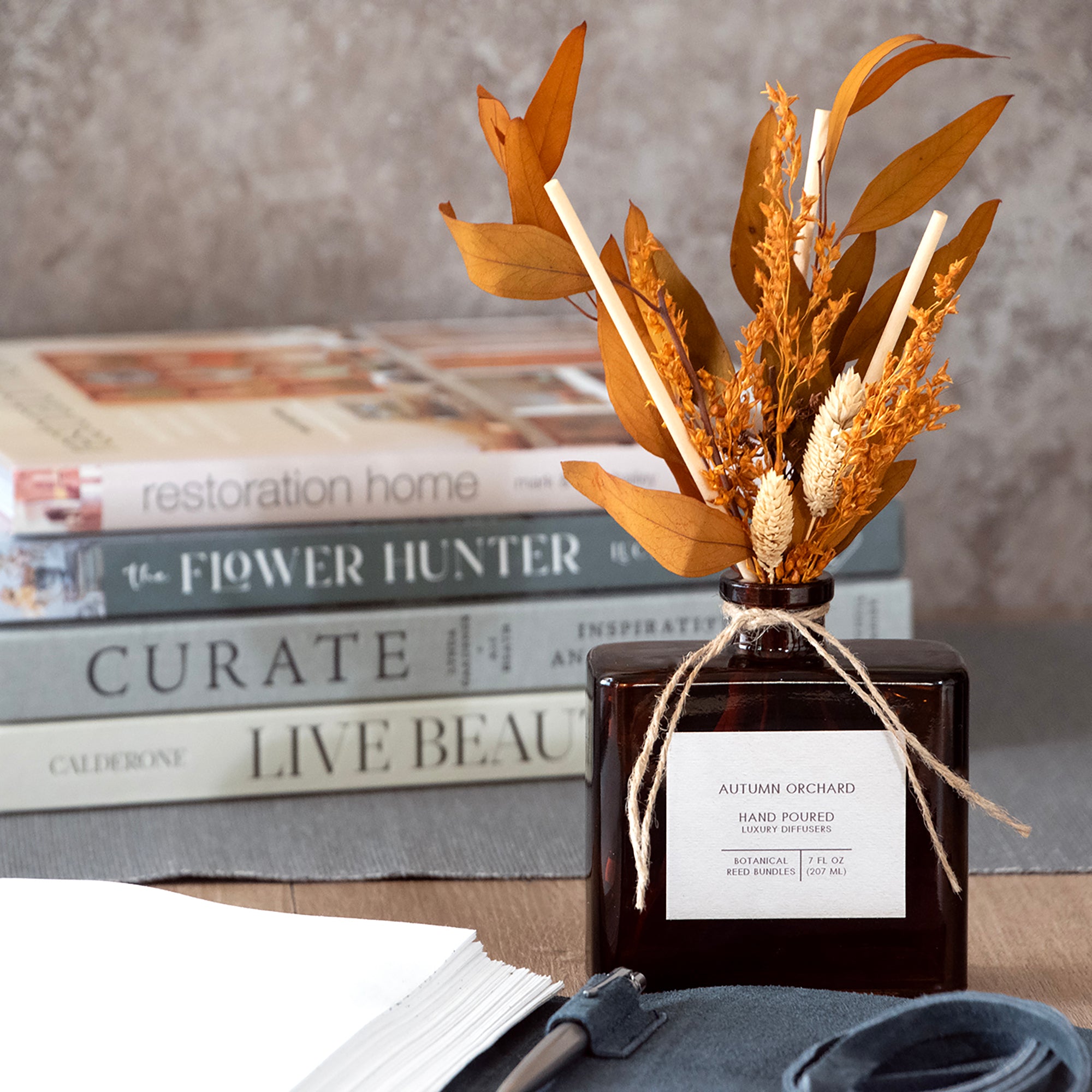 Autumn Orchard hand-filled diffuser, in a room setting.  Diffuser reeds are arranged in an autumn bouquet of dried flowers.