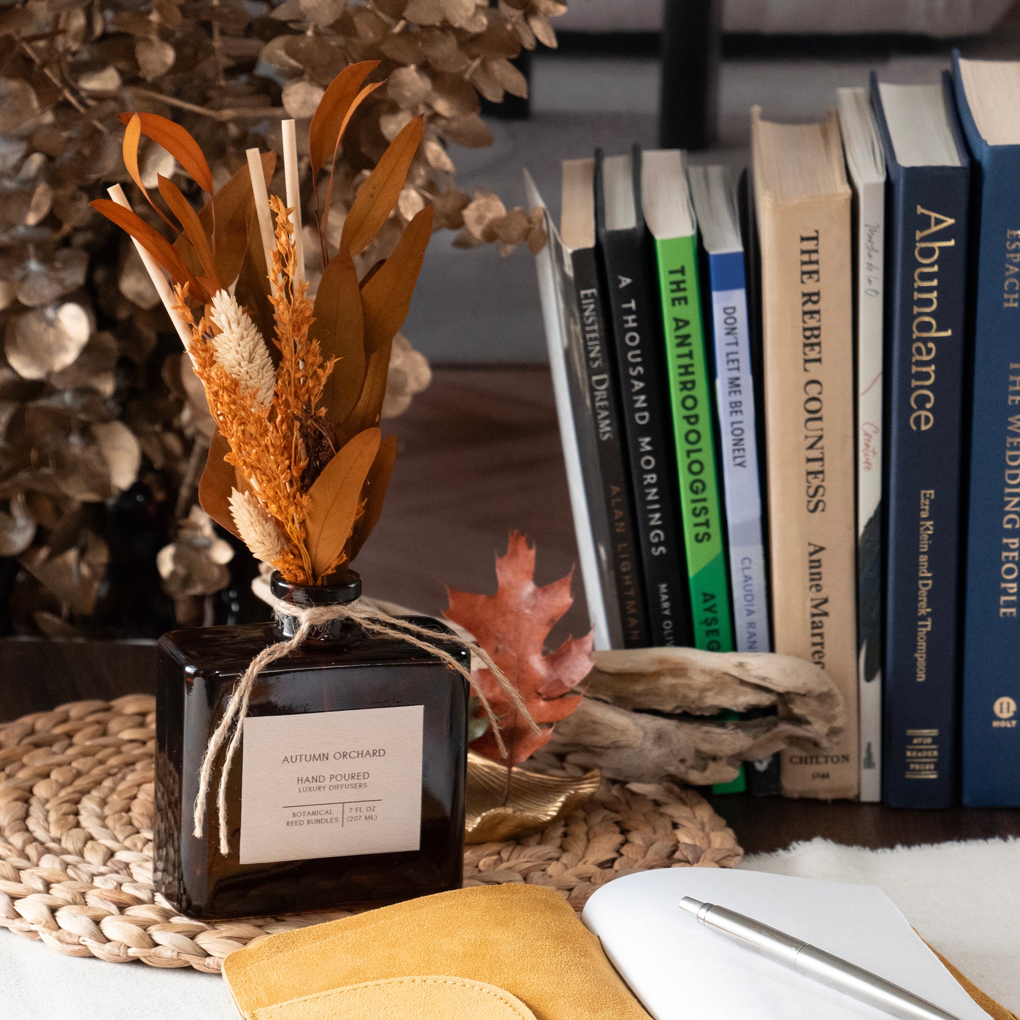 Autumn Orchard hand-filled diffuser, in a room setting.  Diffuser reeds are arranged in an autumn bouquet of dried flowers.