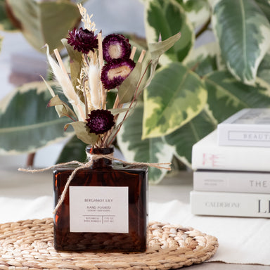 Bergamot Lily reed diffuser with a dried floral bouquet, in a room setting.