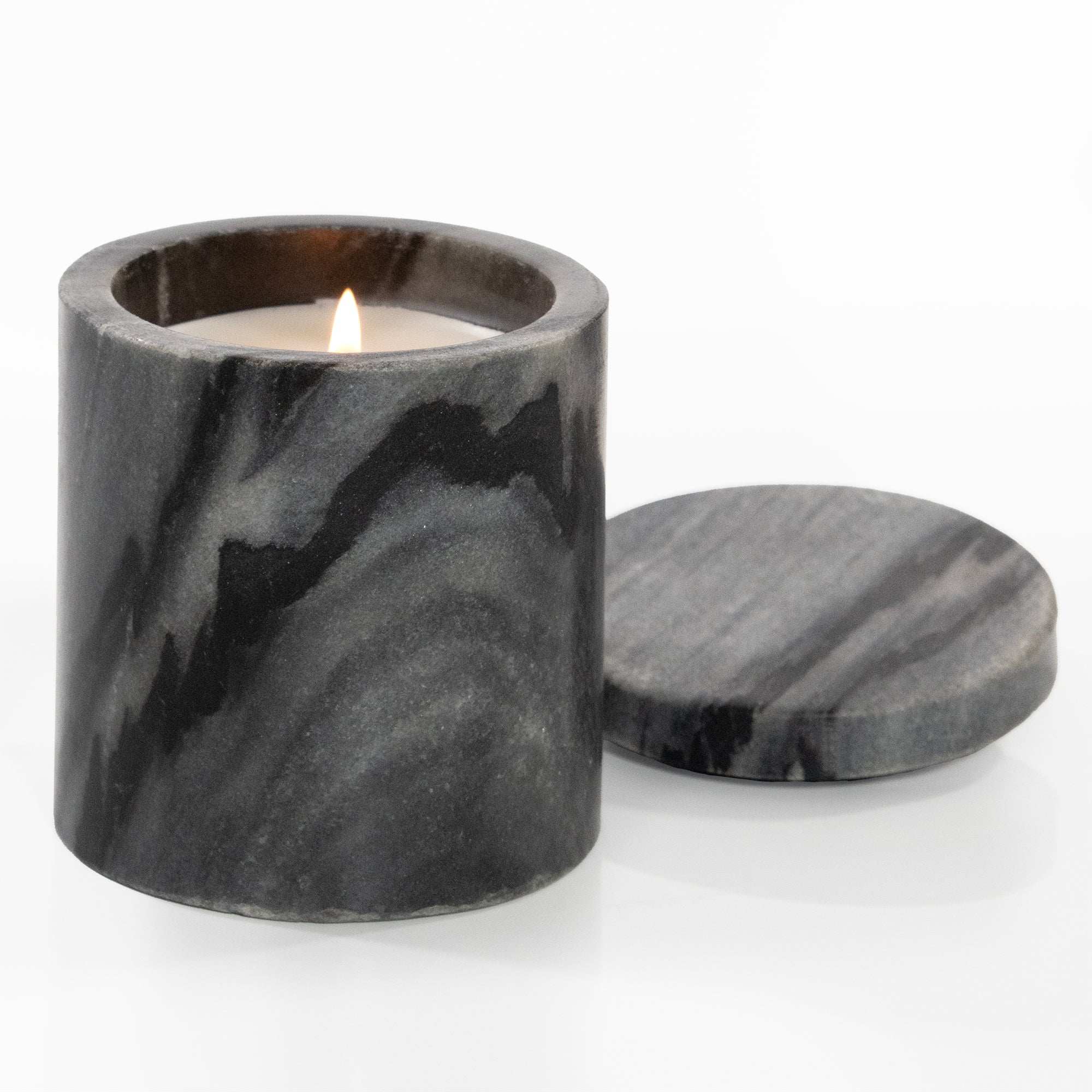 Marble-patterned candle holder with a lit candle on a white background