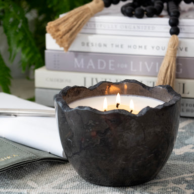 Candle poured into andesite bowl with rough edge.