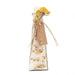 A clear glass bottle filled with white bath salts and dried yellow flowers, tied with twine and a kraft paper tag that reads 'BATH SALTS DAUJA'.