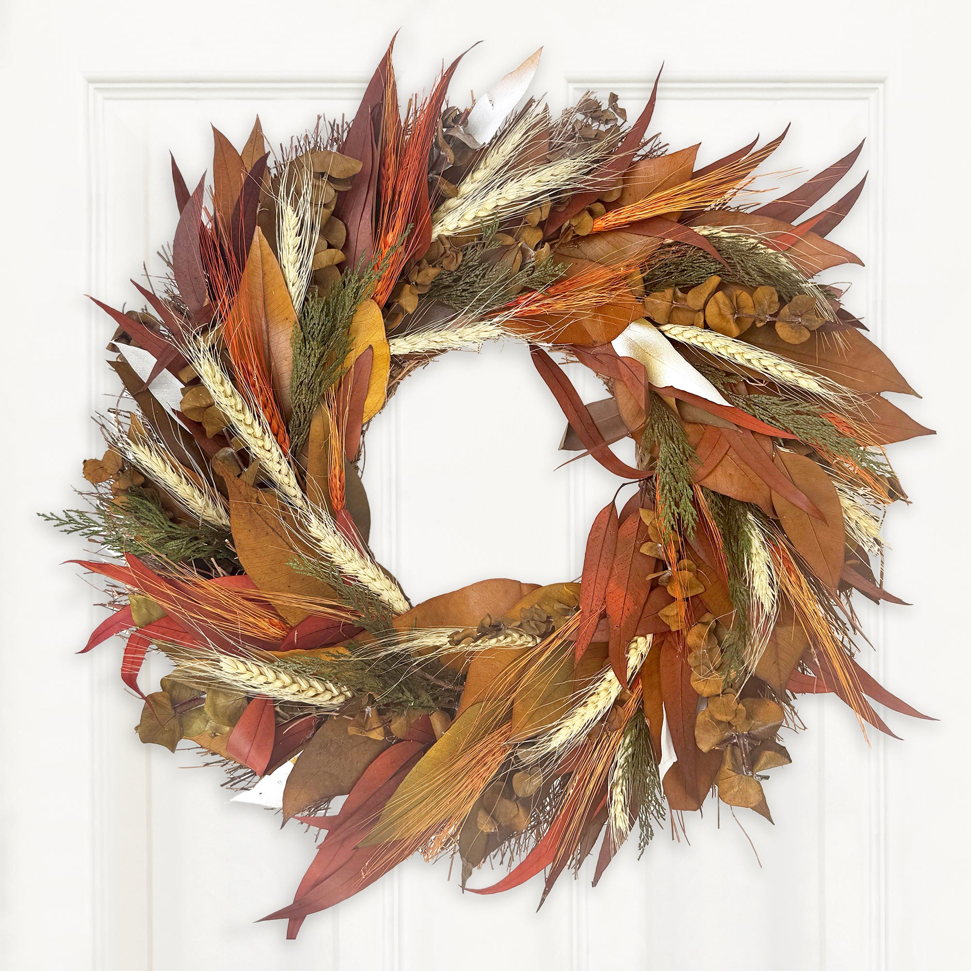 Burnt Orange Autumn Wreath, hanging on a white door.
