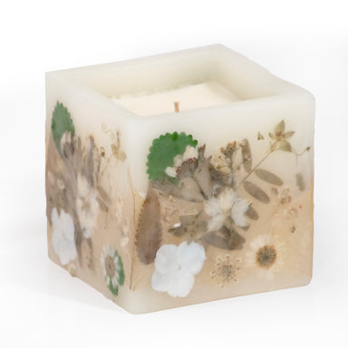 Pressed white flower hurricane candle filled with  wax.