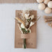 Mini dried floral bouquet in ivory and natural botanicals on kraft backer card.