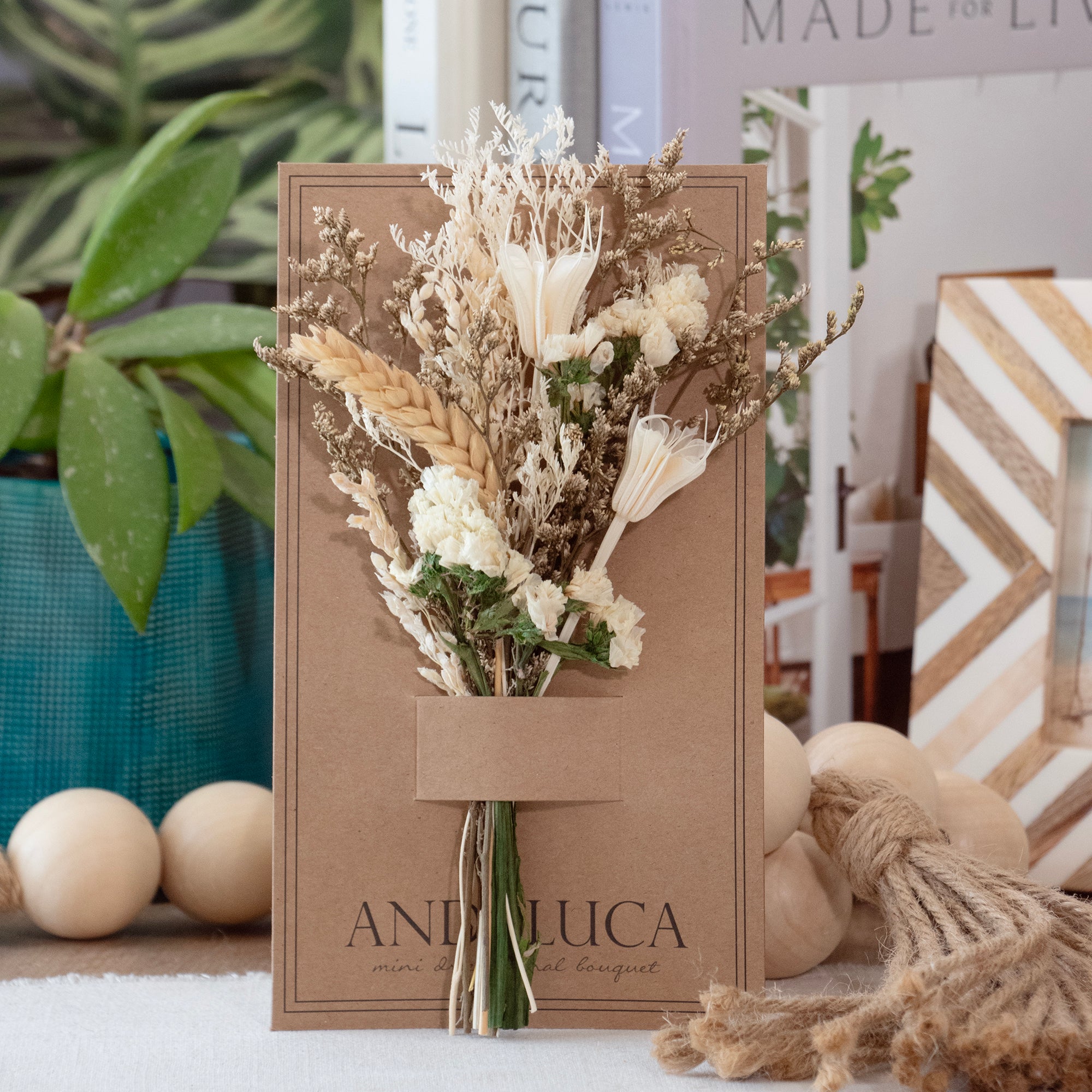 Mini dried floral bouquet in ivory and natural botanicals on kraft backer card.