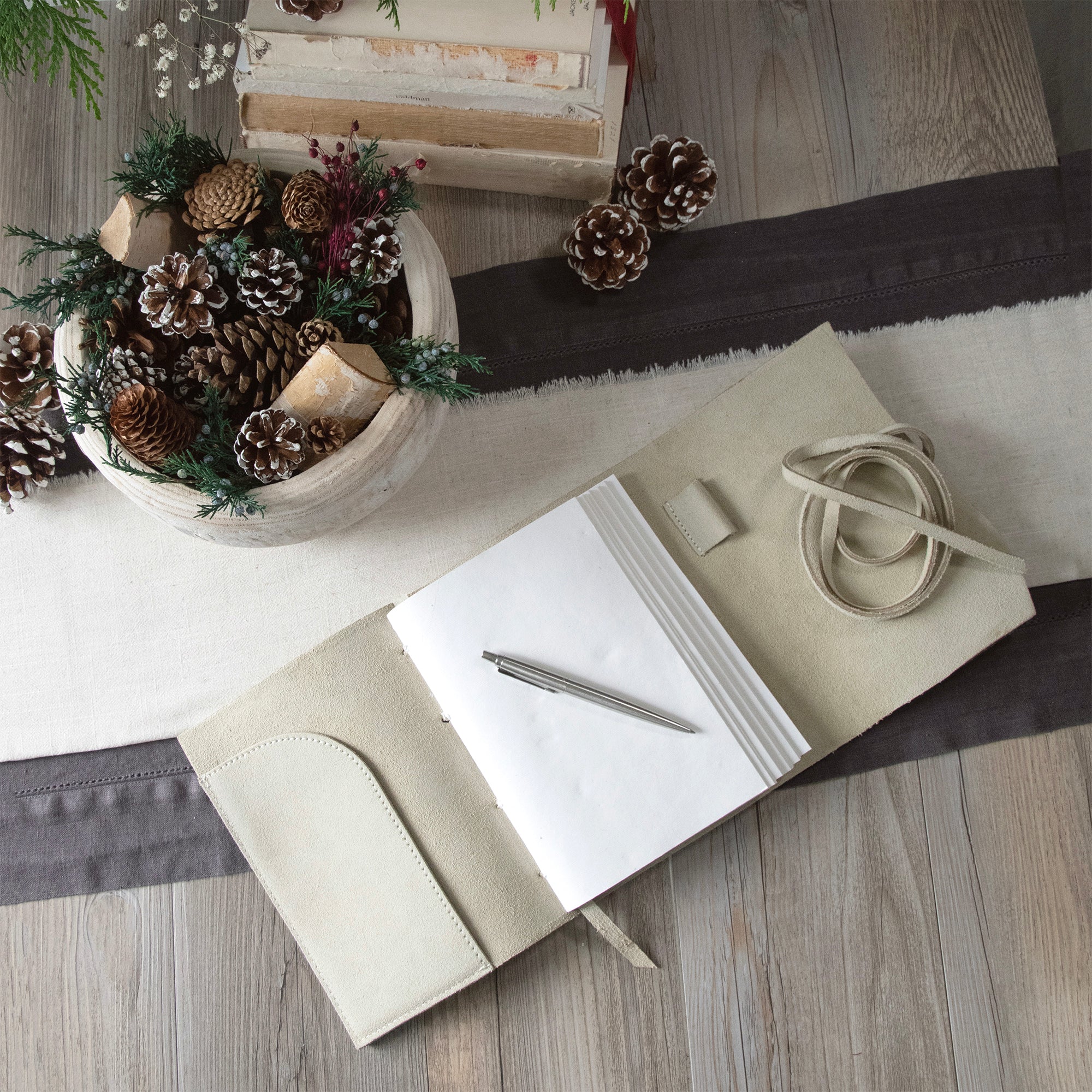 Beige suede journal, open to first page. Top down view.