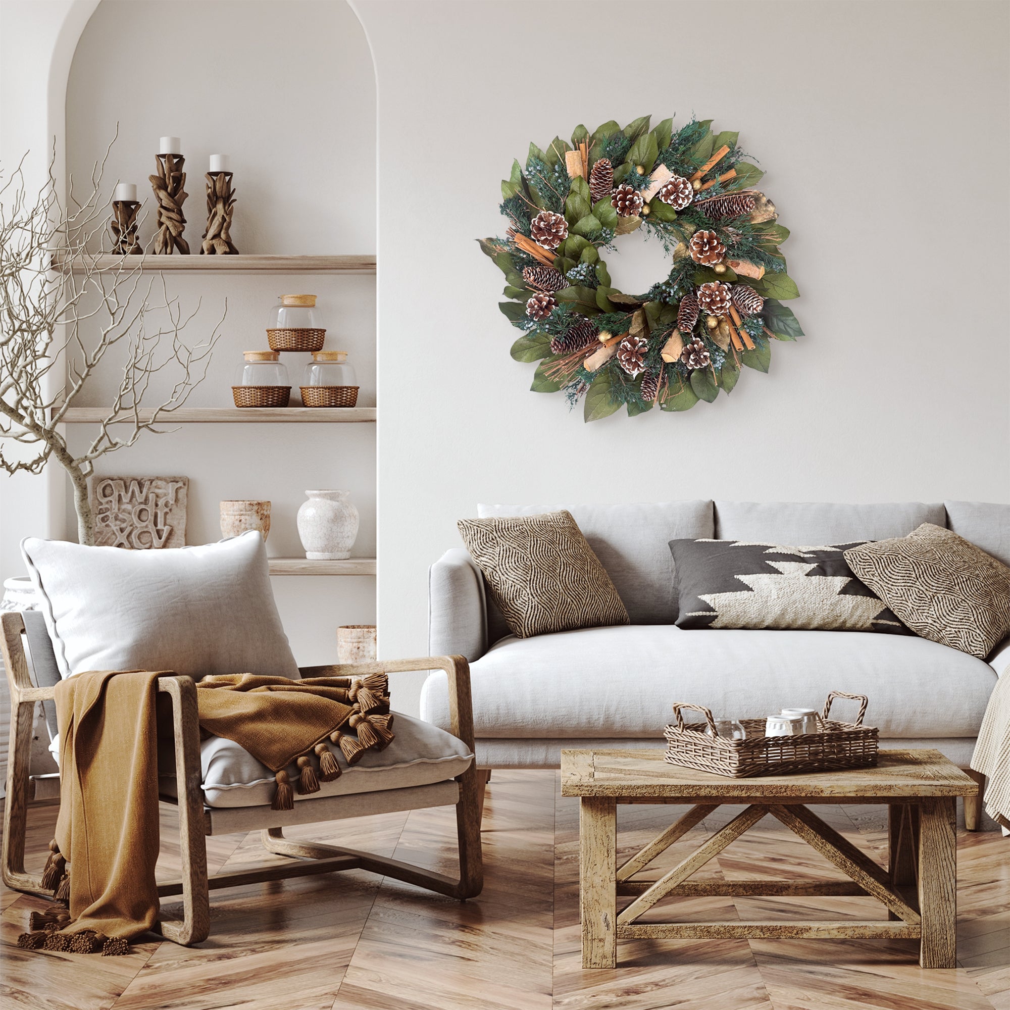 Cozy living room with the Evergreen Pine wreath on the wall, sofa in front of the wall, and armchair off to the left side.