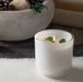 Lite white glass candle vessel with 3 green translucent stones placed in the wax surounding the wick. Stones do not need to be removed while burning.
