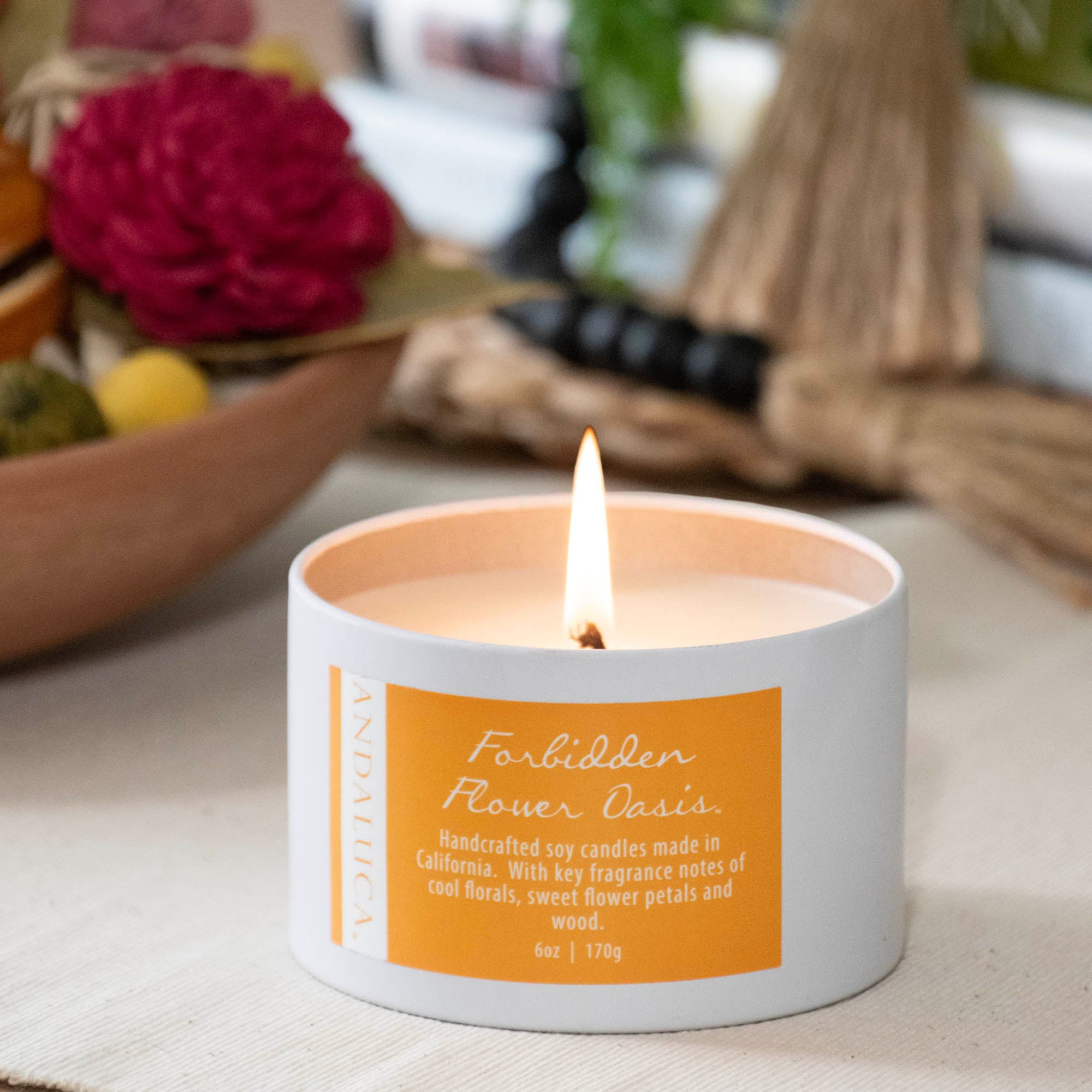Forbidden Flower Oasis Tin Candle, in a room setting.