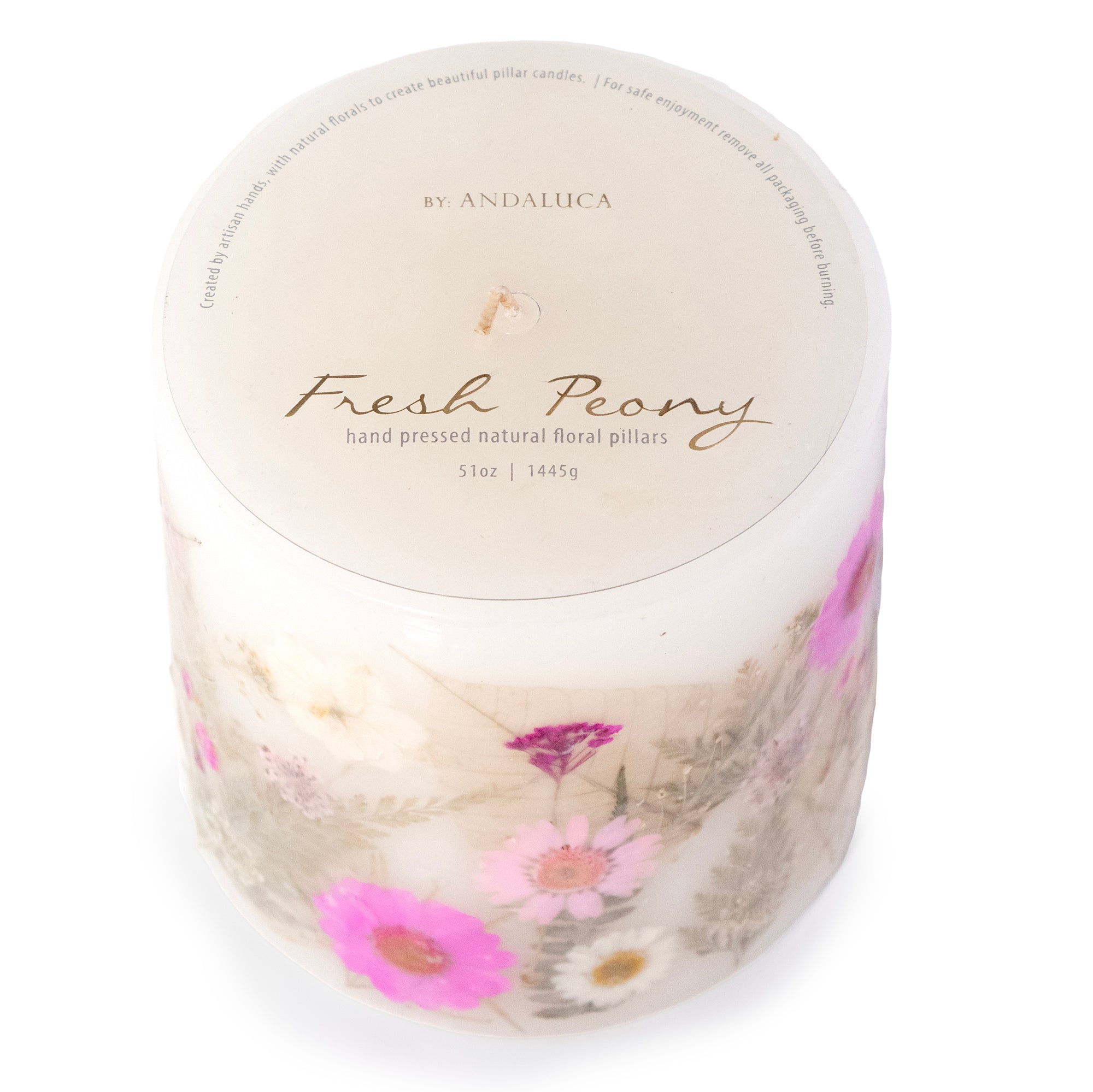 Ivory pillar candle with delicate pink and ivory pressed flowers and green leaves decorating the outside of the candle.