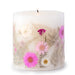 Ivory pillar candle with delicate pink and ivory pressed flowers and green leaves decorating the outside of the candle.