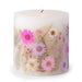 Ivory pillar candle with delicate pink and ivory pressed flowers and green leaves decorating the outside of the candle.