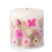 Ivory pillar candle with delicate pink and ivory pressed flowers and green leaves decorating the outside of the candle.