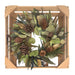 Decorative wreath with pine cones and greenery in a wooden frame on a white background