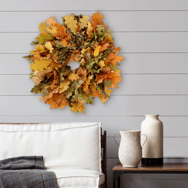 wreath hanging on gray shiplap wall, above a cushion bench seat & table.