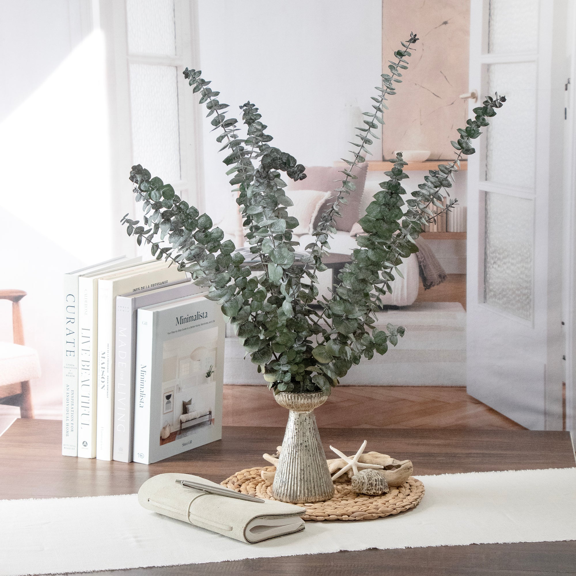 Green Baby Eucalyptus Preserved Bundle in a vase, set on a table.