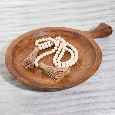 Photo of round teak wood platter with one large handle.