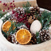 Close up of the Holiday Memories Burlap Pinecone bag is displaed in a white wood bowl. 