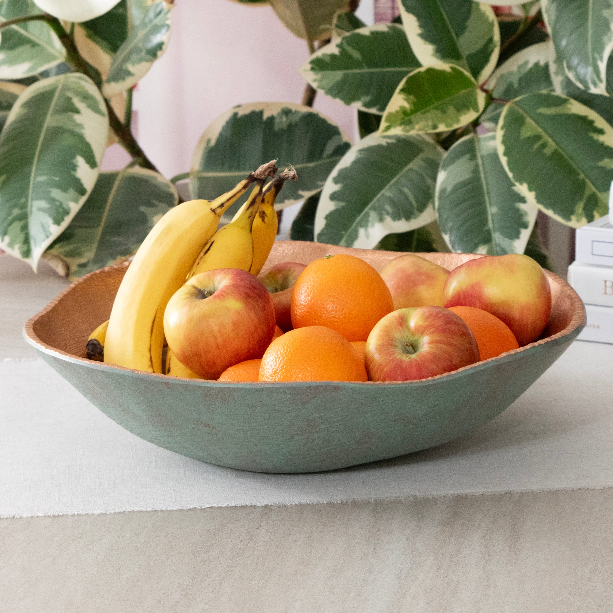 Large Round Turquoise Copper Cast Metal Decorative Bowl, in a room setting with fruit.