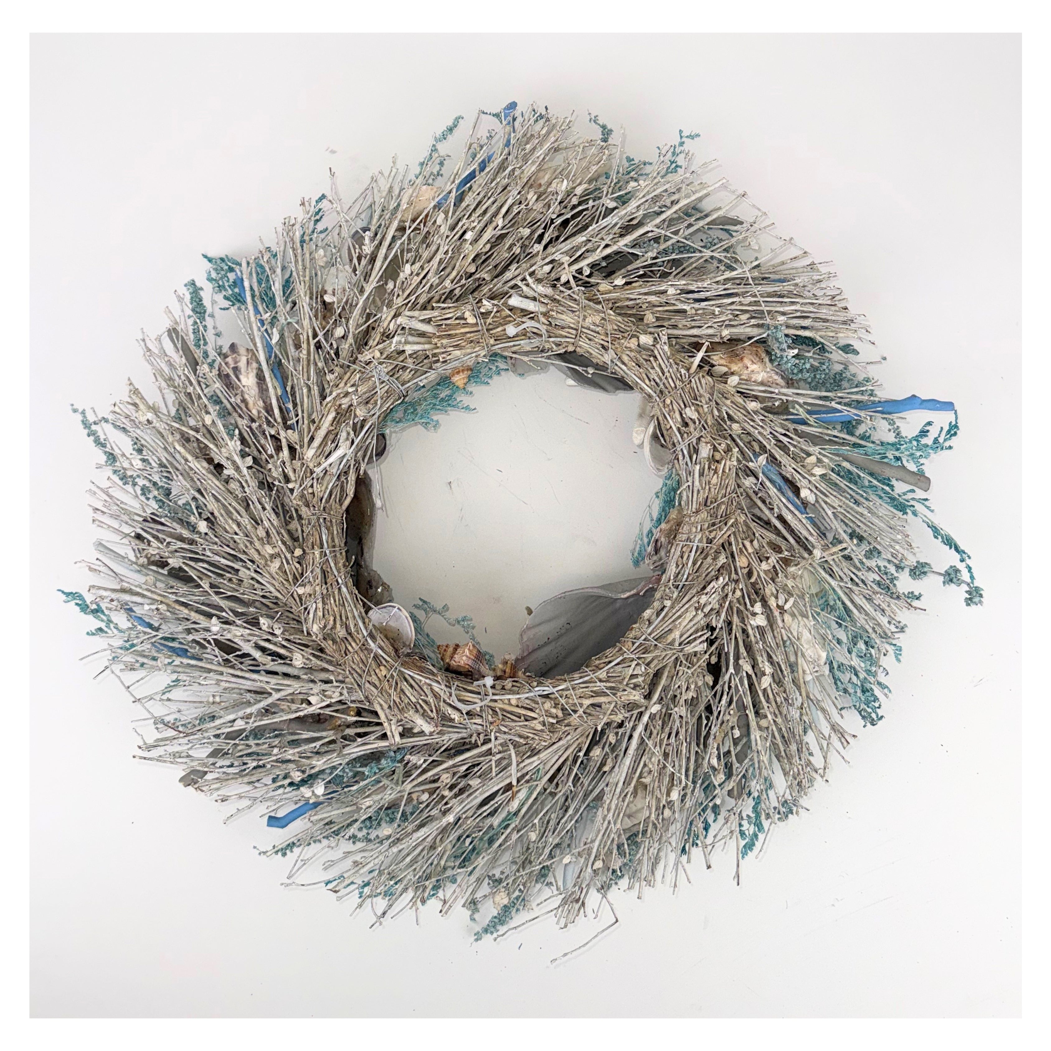 Decorative wreath with branches and small figurines on a white background