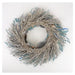 Decorative wreath with branches and small figurines on a white background