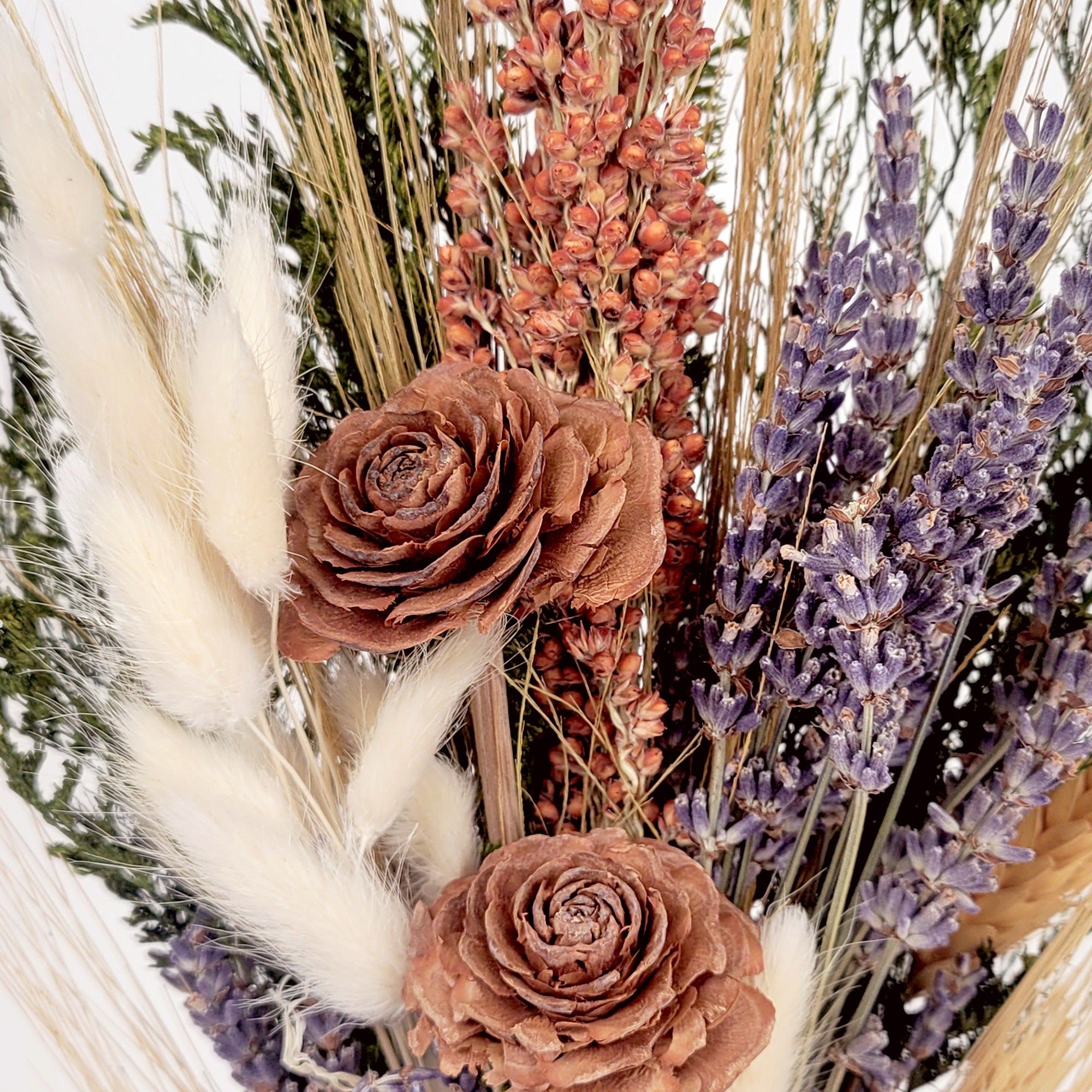 Arrangement of dried flowers including lavender and roses with a soft focus background
