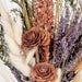 Arrangement of dried flowers including lavender and roses with a soft focus background
