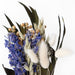 Close up of Mini bouquet with purple larkspur, willow eucalyptus, bunny tails, flax, and aveena.