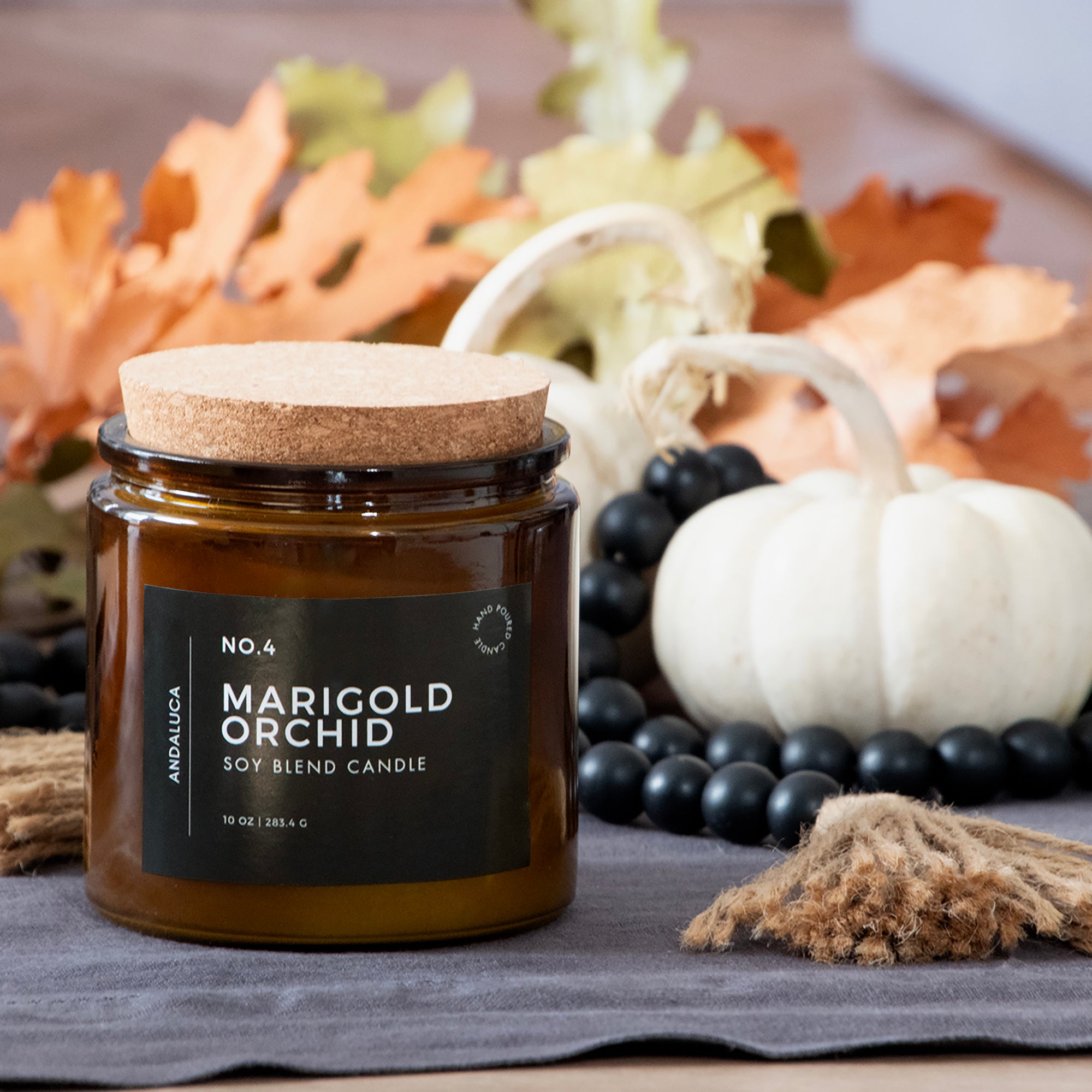 Marigold Orchid candle with autumn decorations in the background.