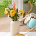 Decorative vase with flowers on a surface with a blurred background