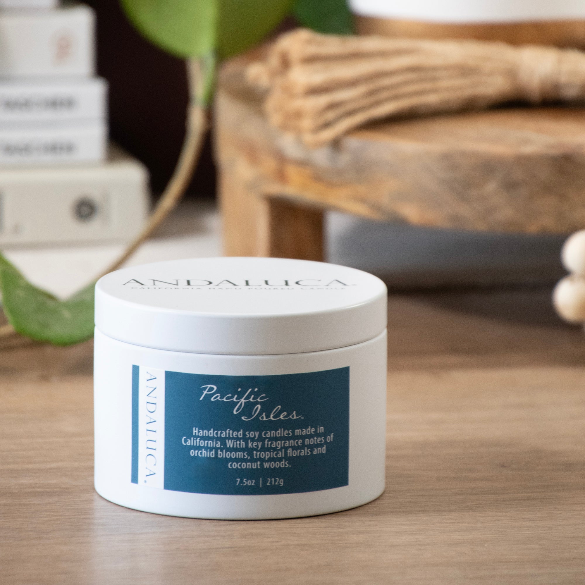 Pacific Isles tin candle on a table. lid closed.