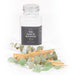 Contents of jar placed in font of the empty jar. palo santo, eucalyptus and stones a pile.