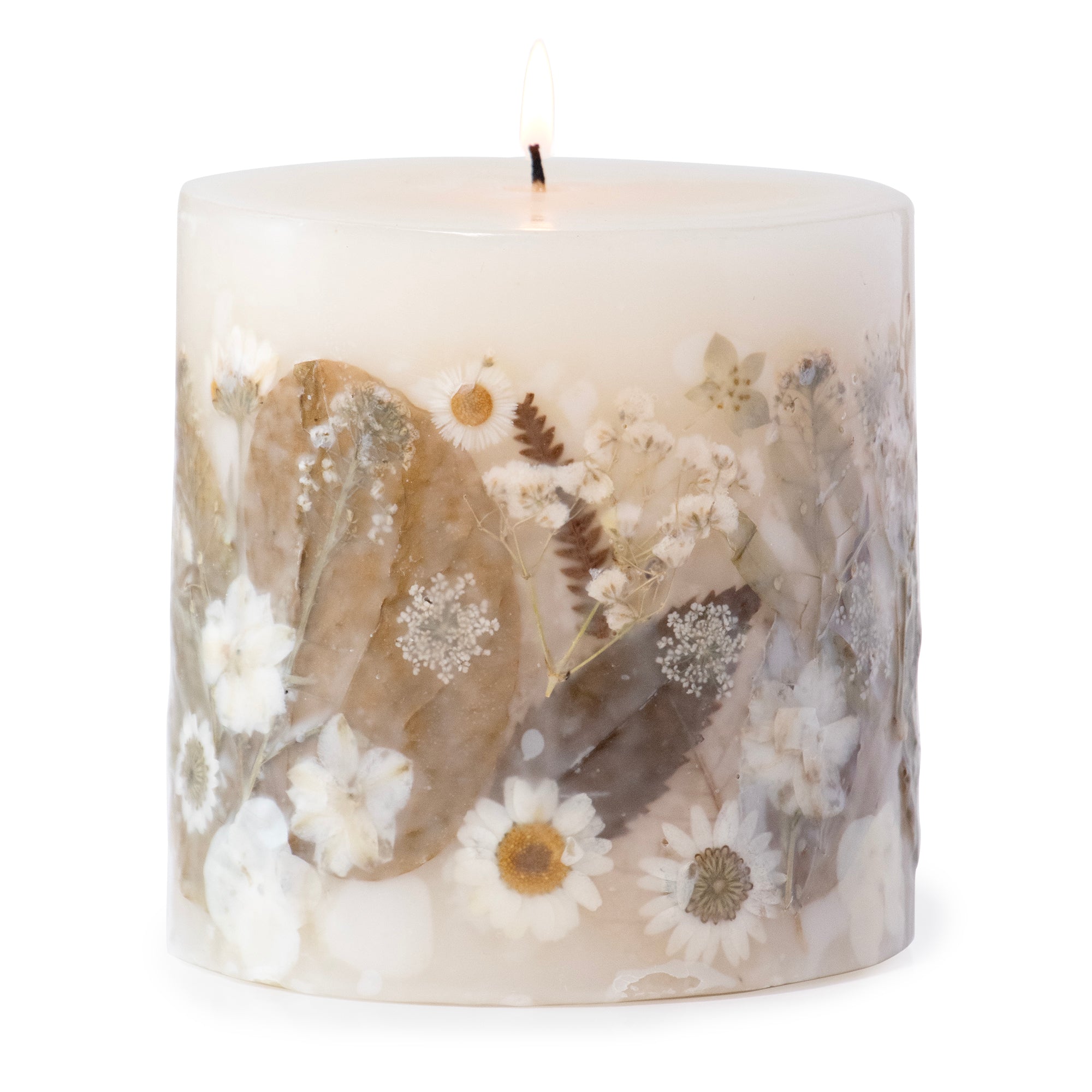 Ivory pillar candle with delicate white pressed flowers and green leaves decorating the outside of the candle.