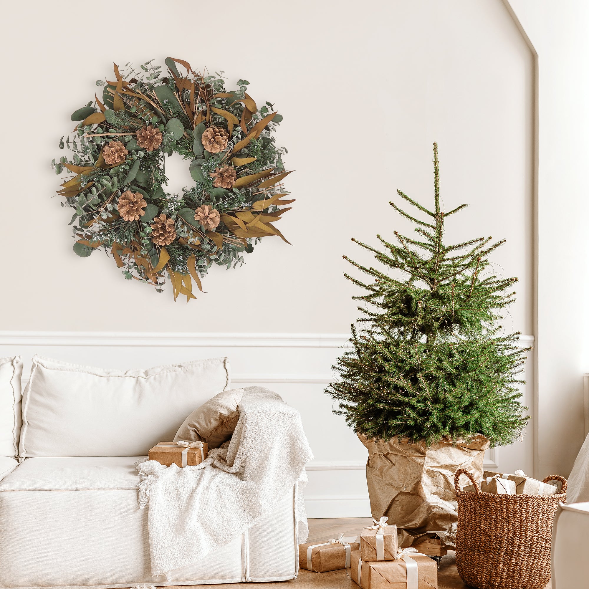 Decorative wreath with greenery, pinecones, and brown leaves in a holiday room setting.