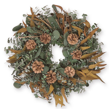 Decorative wreath with greenery, pinecones, and brown leaves on a white background